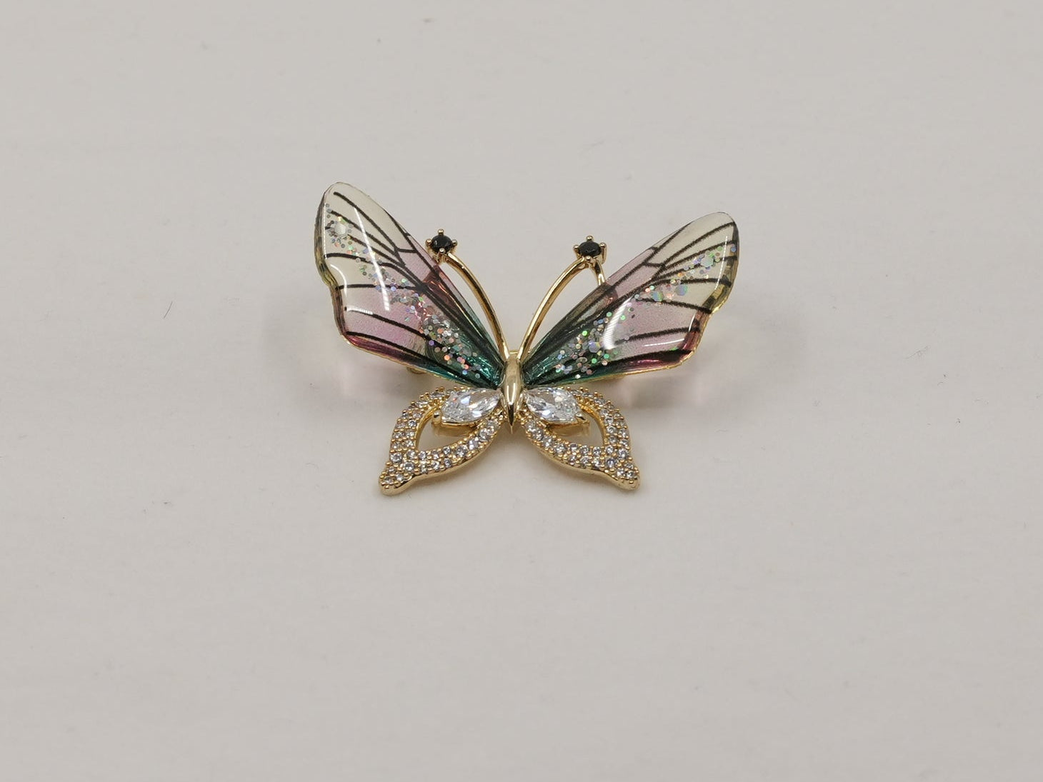 Butterfly-shaped brooch on a light gray background