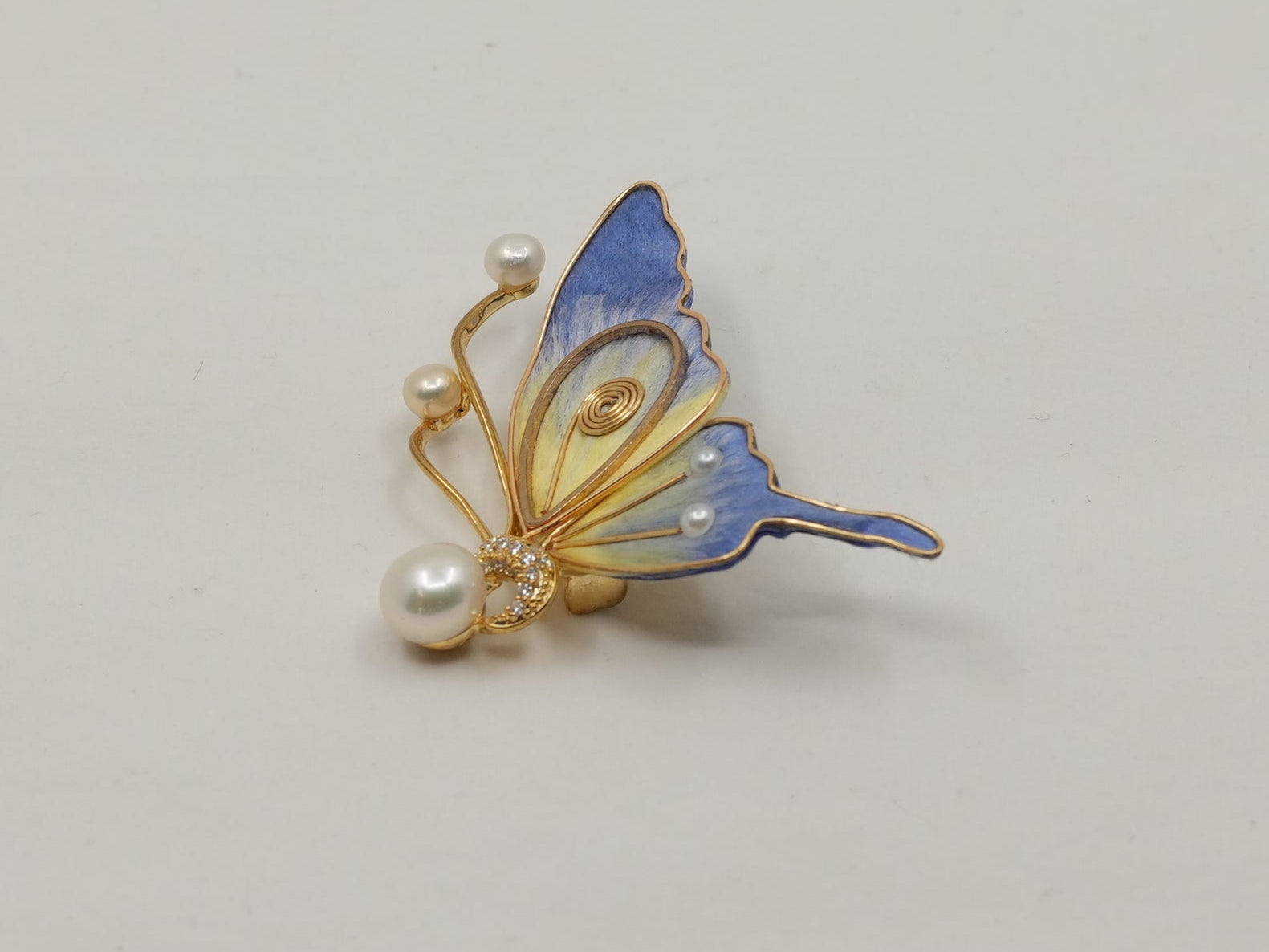 Small butterfly-shaped earring on a light gray background