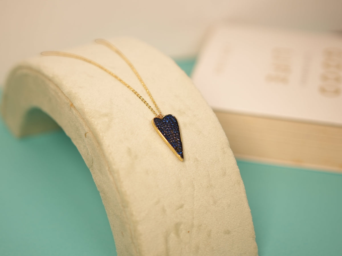 Daga-accessories dainty heart pendant necklace with shimmering blue textured finish and polished gold-tone setting.