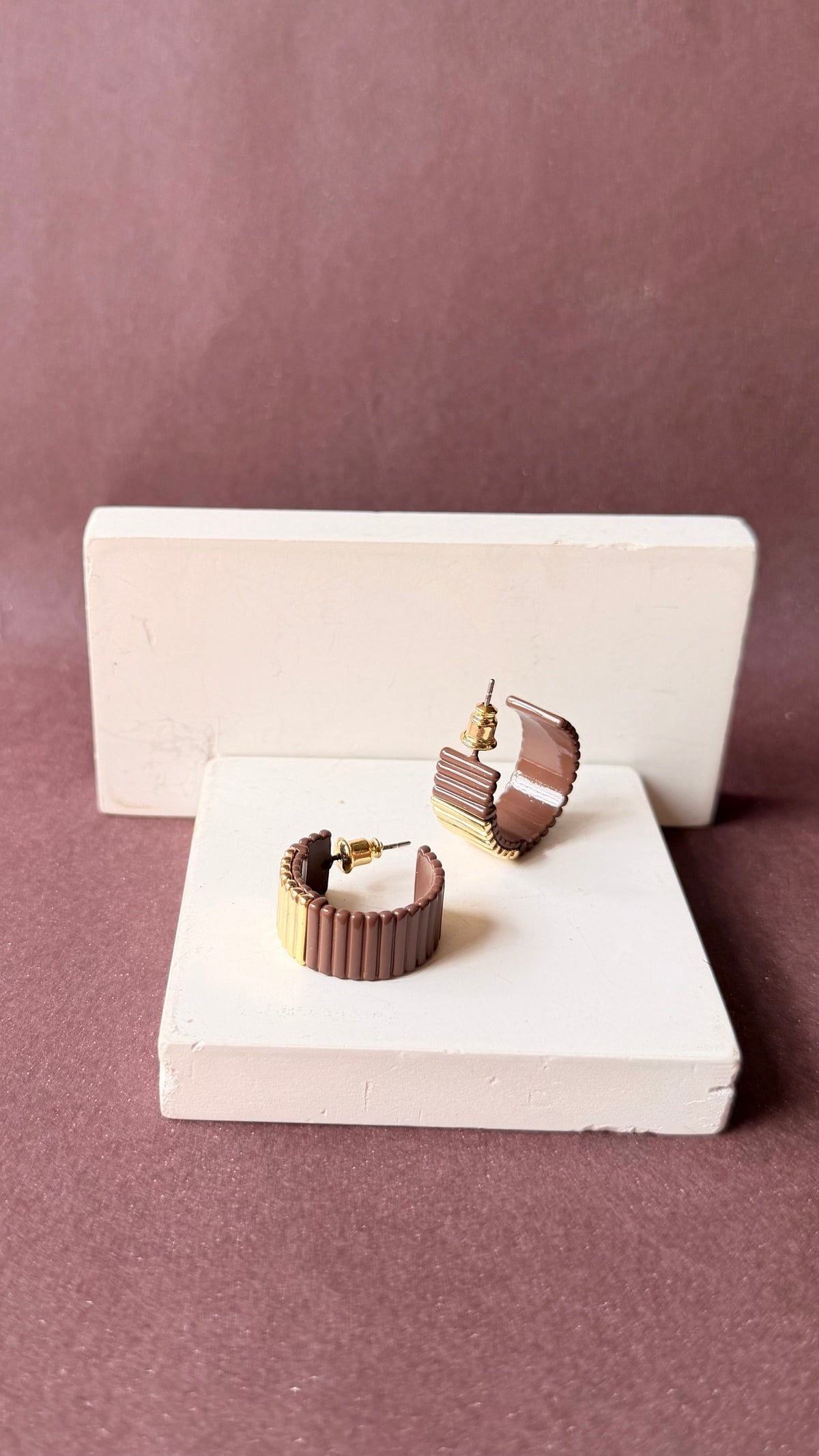 Daga-accessories two-tone chocolate brown and gold textured hoop earrings with a ribbed surface and post-back closure.