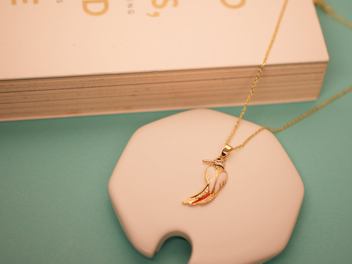 Daga-accessories Canary Song necklace featuring a white and gold bird pendant on a delicate gold chain