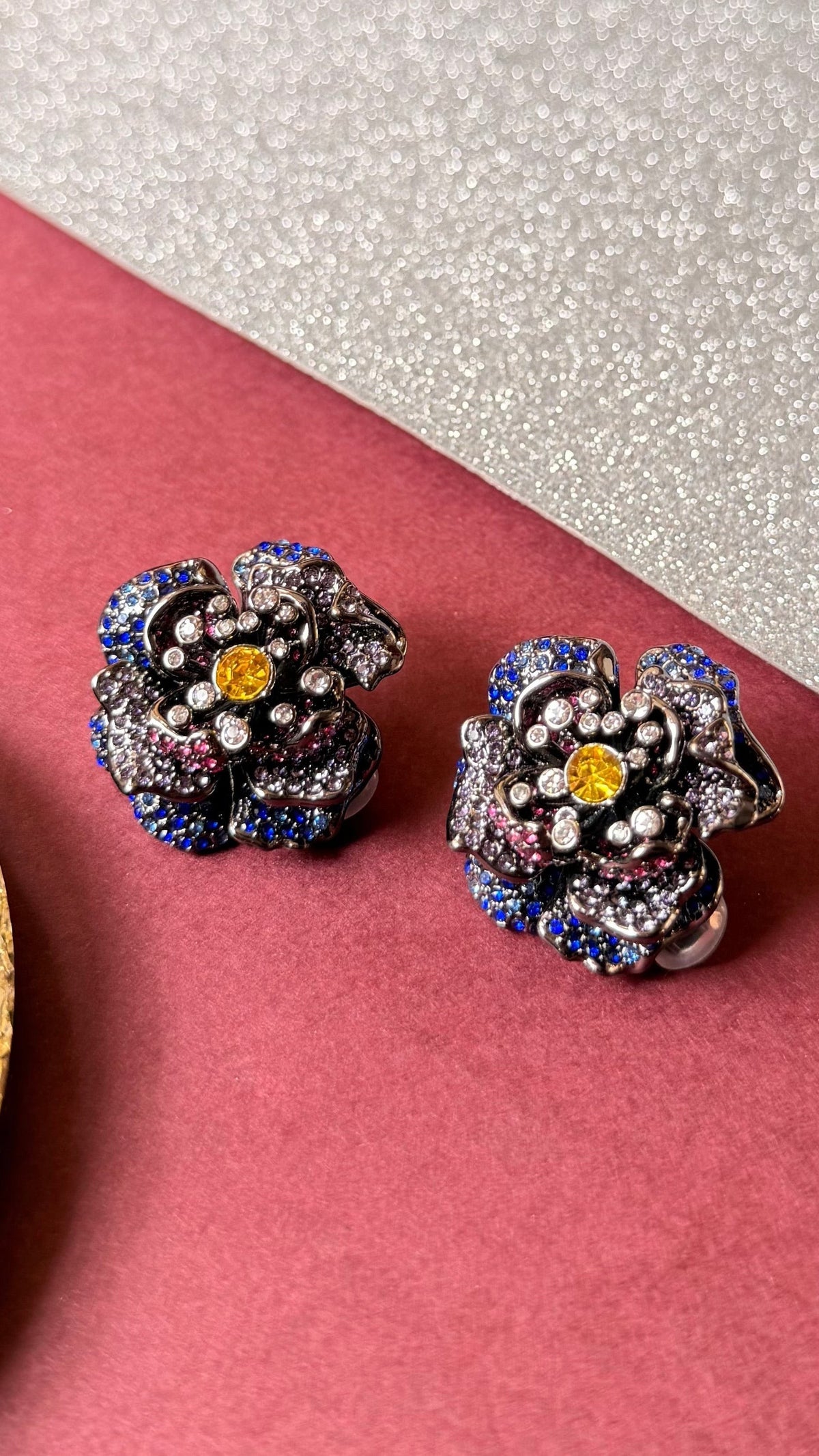 Daga-accessories Colourburst bloom floral statement earrings with vibrant blue, pink, and yellow crystal embellishments.