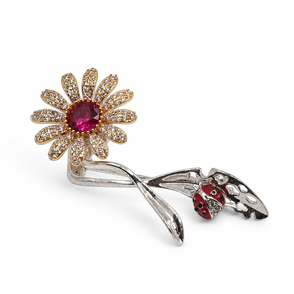 Daga-accessories Daisy Delight brooch featuring a crystal daisy with a pink stone center and a red ladybug accent.
