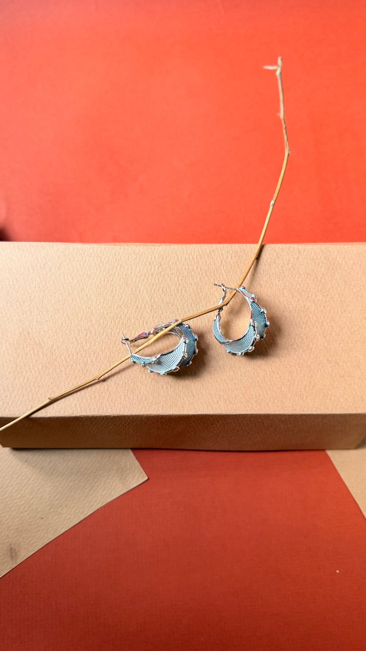 Daga-accessories denim-colored hoop earrings featuring silver, beige accents, and delicate gold bead embellishments.