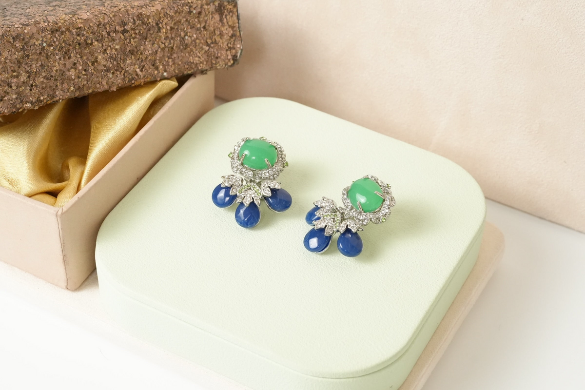 Daga-accessories gemstone stud earrings featuring green jade cabochons, blue teardrop stones, and white crystal halos.