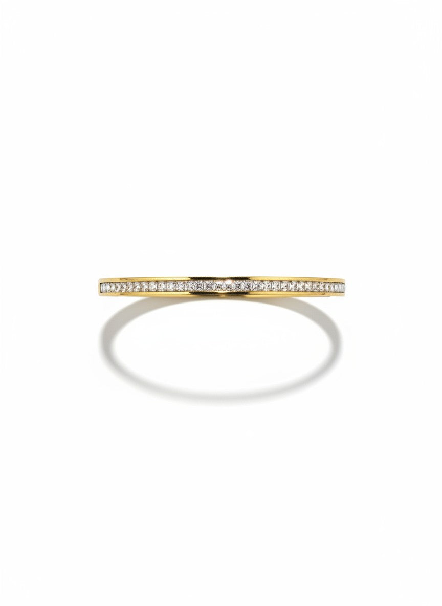 Daga-accessories gold-toned bangle bracelet featuring a row of clear crystals in a minimalist polished metal design.