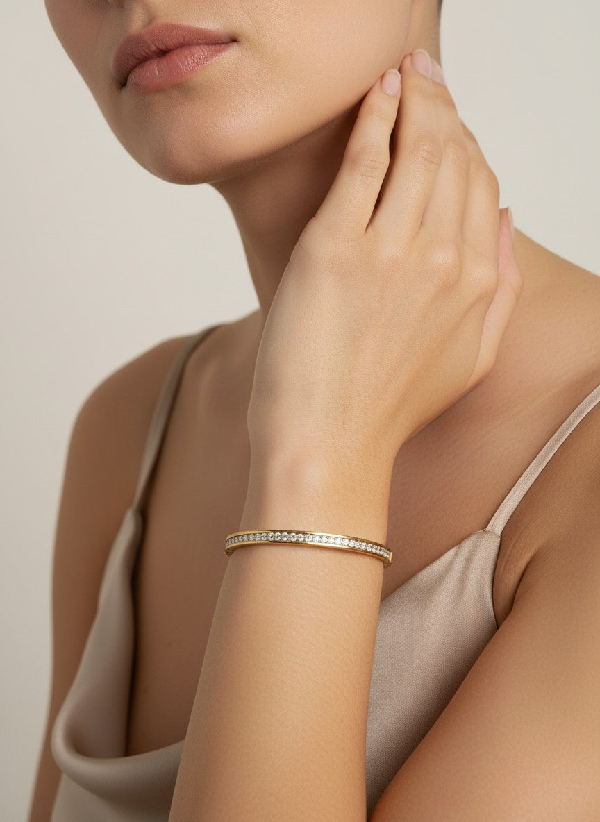 Daga-accessories gold-toned bangle bracelet featuring a row of shimmering cubic zirconia stones on a woman's wrist