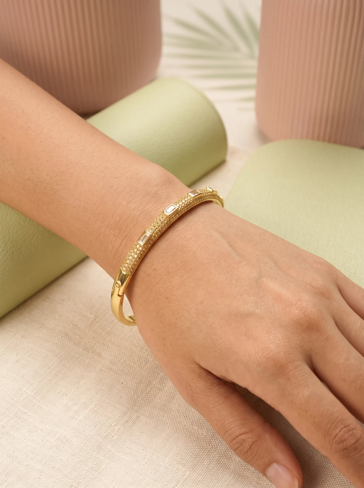 Daga-accessories gold Diamond Glow bracelet featuring baguette-cut stones and textured studs on a woman's wrist