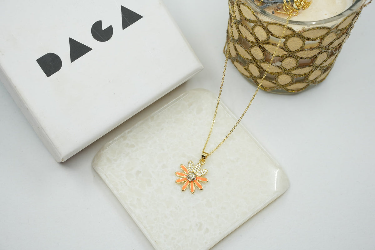 Daga-accessories gold stainless steel necklace featuring a dainty orange enamel flower pendant with crystal center