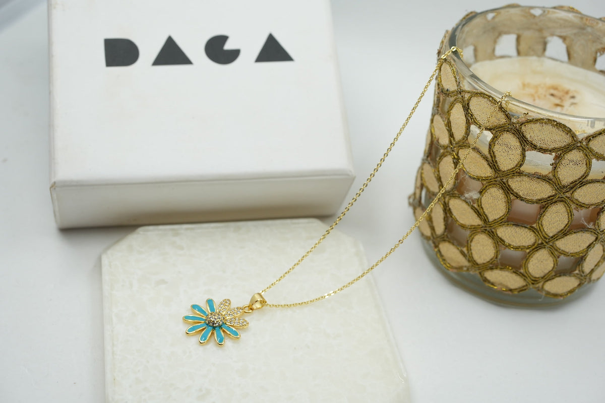 Daga-accessories gold stainless steel necklace featuring a blue enamel flower pendant with sparkling crystal center