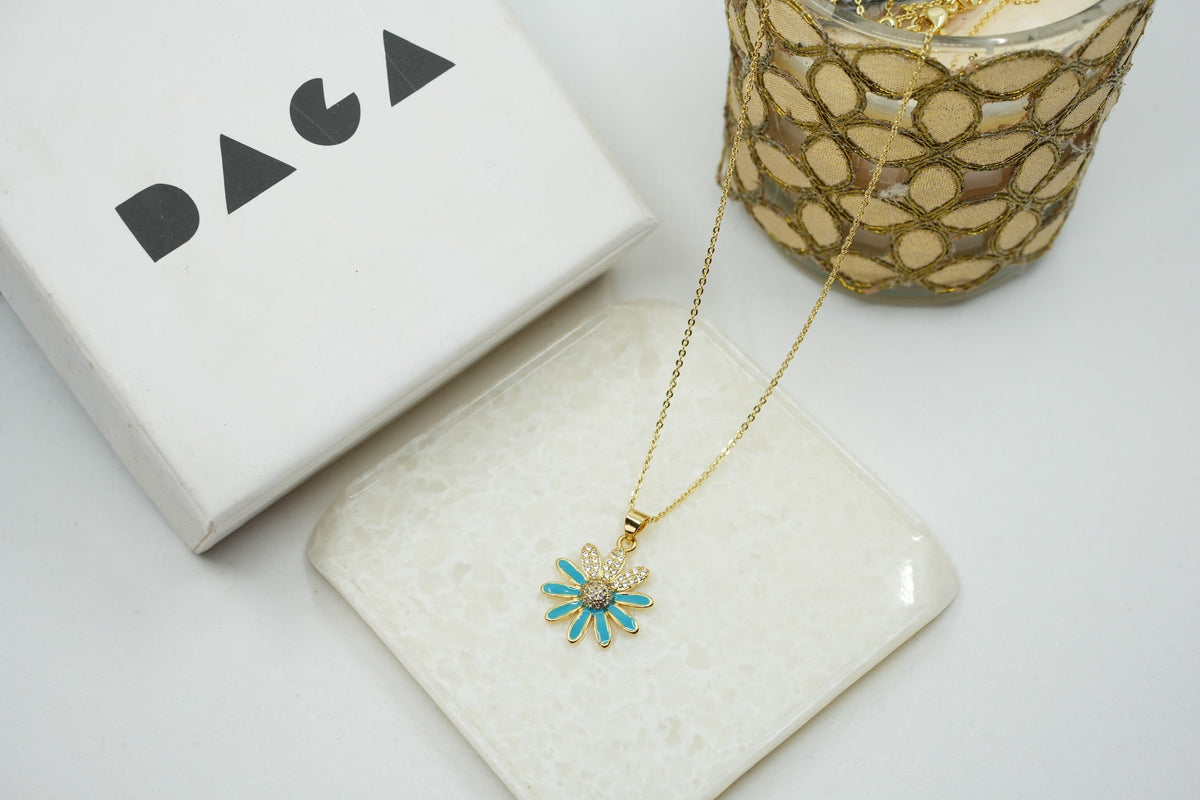 Daga-accessories gold stainless steel necklace with a blue enamel flower pendant and sparkling crystal center