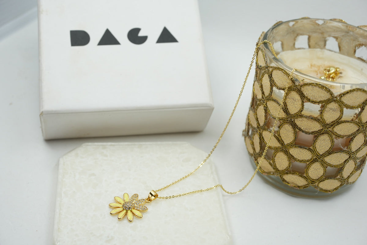 Daga-accessories gold stainless steel necklace featuring a delicate enamel flower pendant with crystal accents.