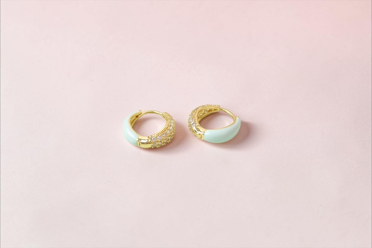 Daga-accessories gold-plated huggie hoop earrings with pastel blue enamel and sparkling cubic zirconia stones.