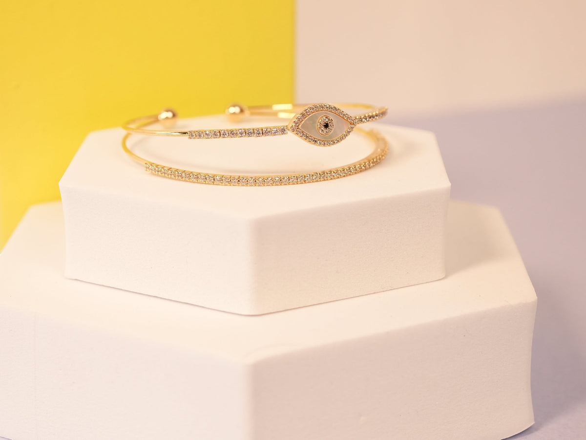 Daga-accessories gold-tone bangle bracelet with a mother-of-pearl evil eye motif and pavé crystal accents.