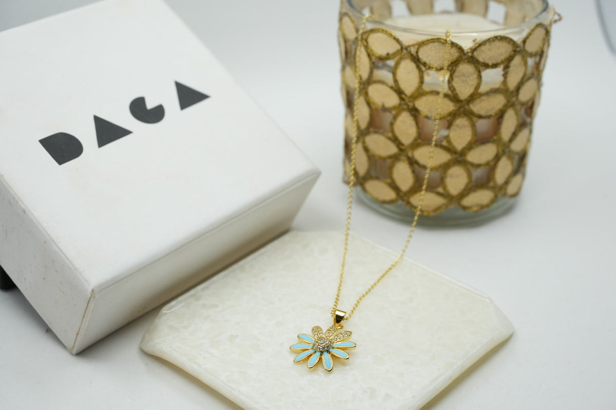 Daga-accessories gold chain necklace with a blue enamel flower pendant featuring a sparkling crystal center
