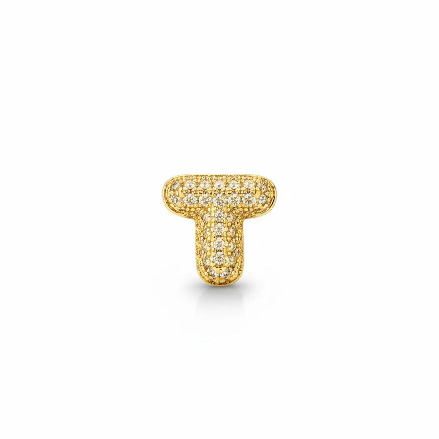 Daga-accessories gold-tone letter T pendant charm featuring a shimmering pavé-style finish on a white background.