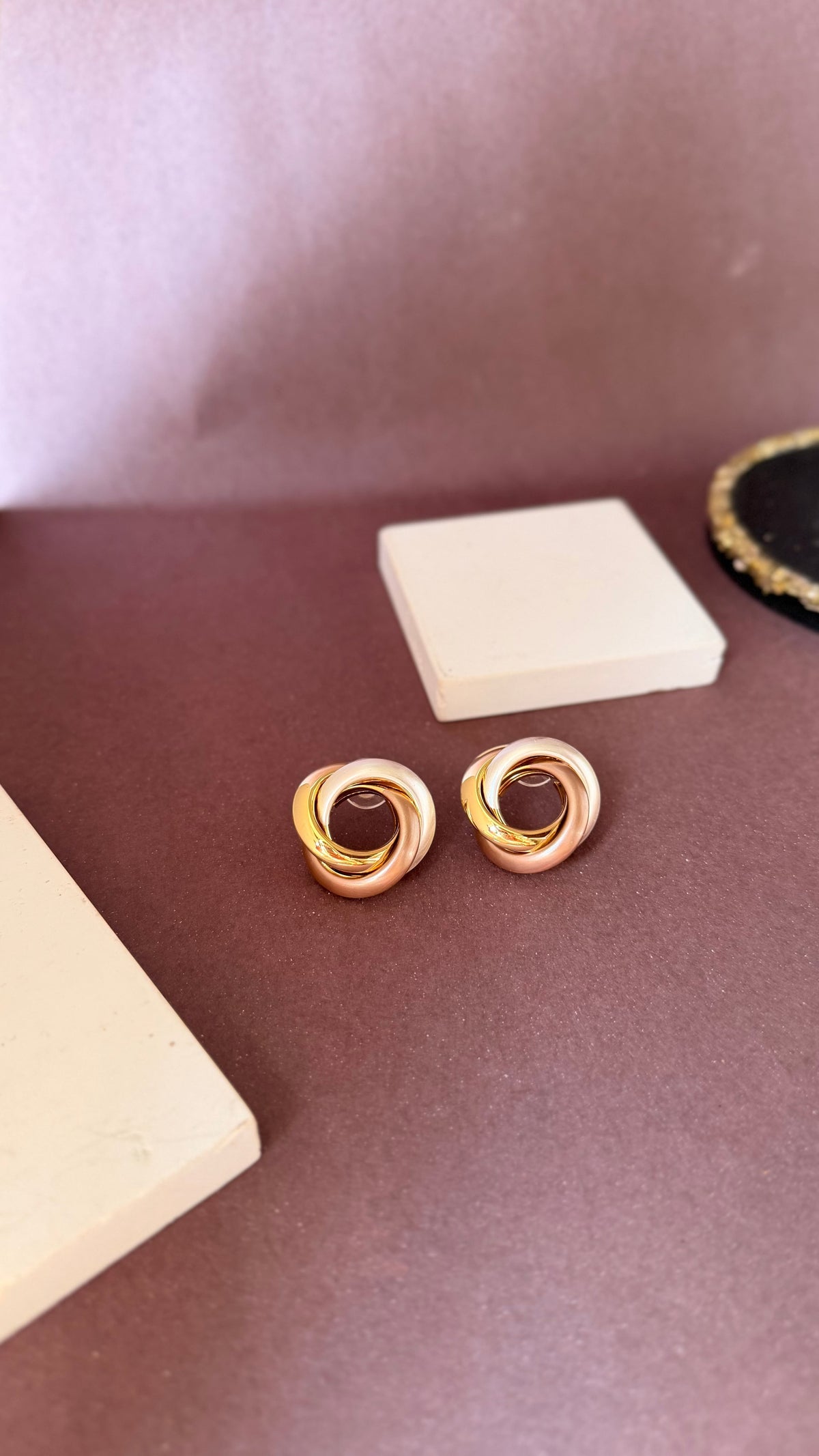 Daga-accessories gold-toned swirl earrings with mocha accents, featuring a bold, elegant circular design.