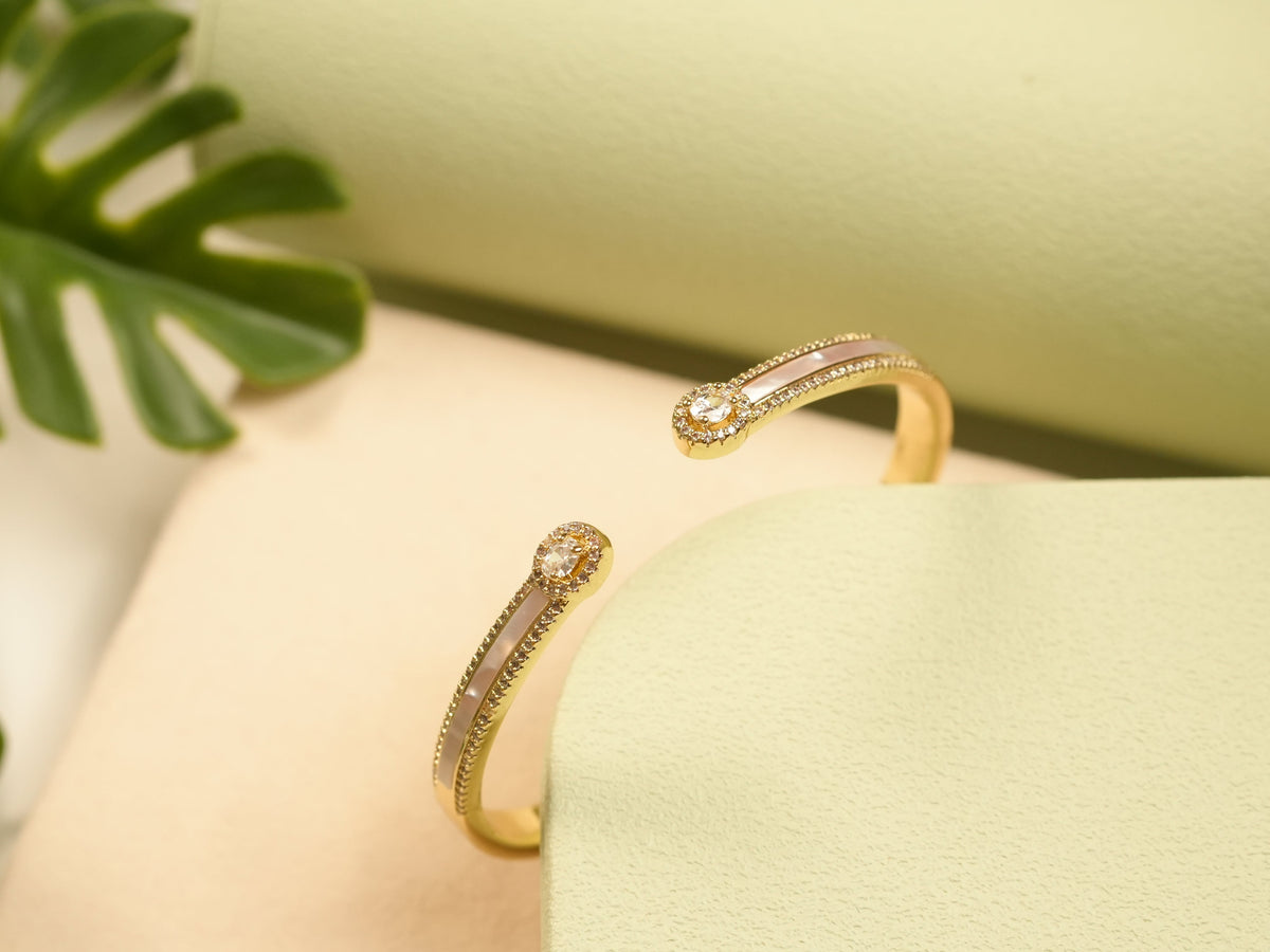 Daga-accessories Gold Pearl Radiance Bracelet featuring a gold cuff design with lustrous pearl inlay and crystal studs.