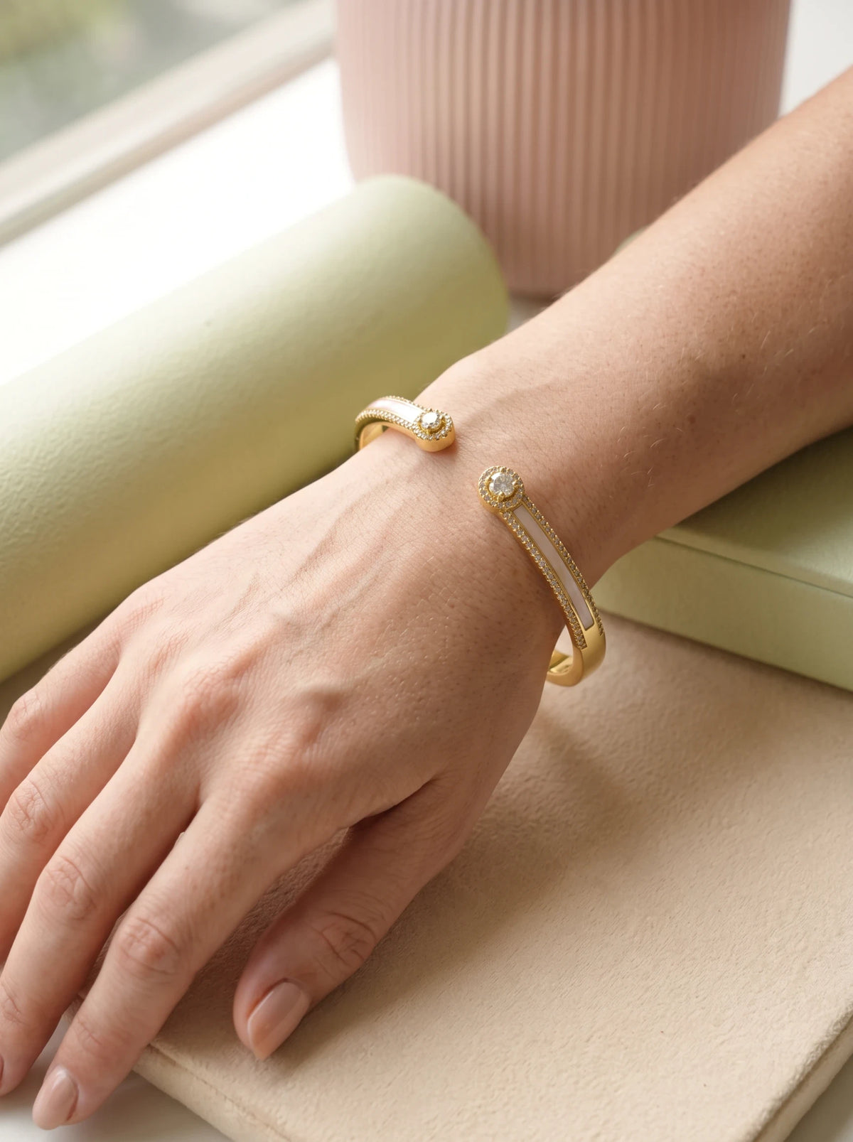 Daga-accessories Gold Pearl Radiance Bracelet featuring a gold cuff with white inlay and sparkling stud accents.