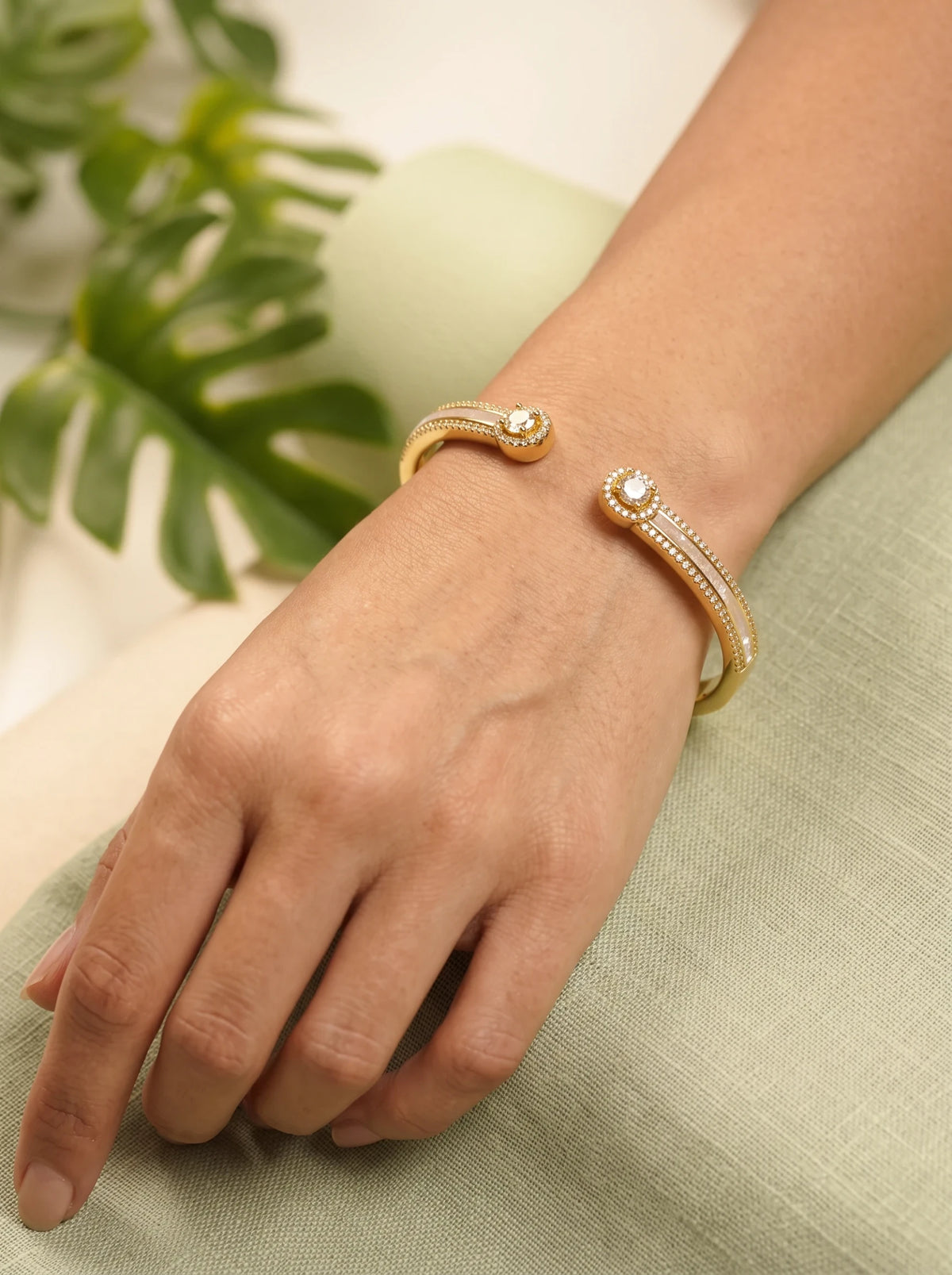 Daga-accessories Gold Pearl Radiance Bracelet featuring a gold cuff design with pearl accents and sparkling studs.