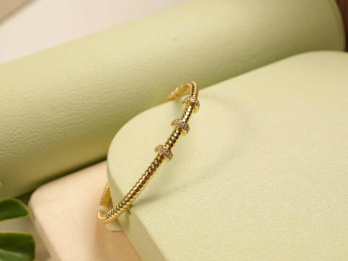 Daga-accessories gold-toned metal bangle bracelet with ribbed texture and three crystal-encrusted stations