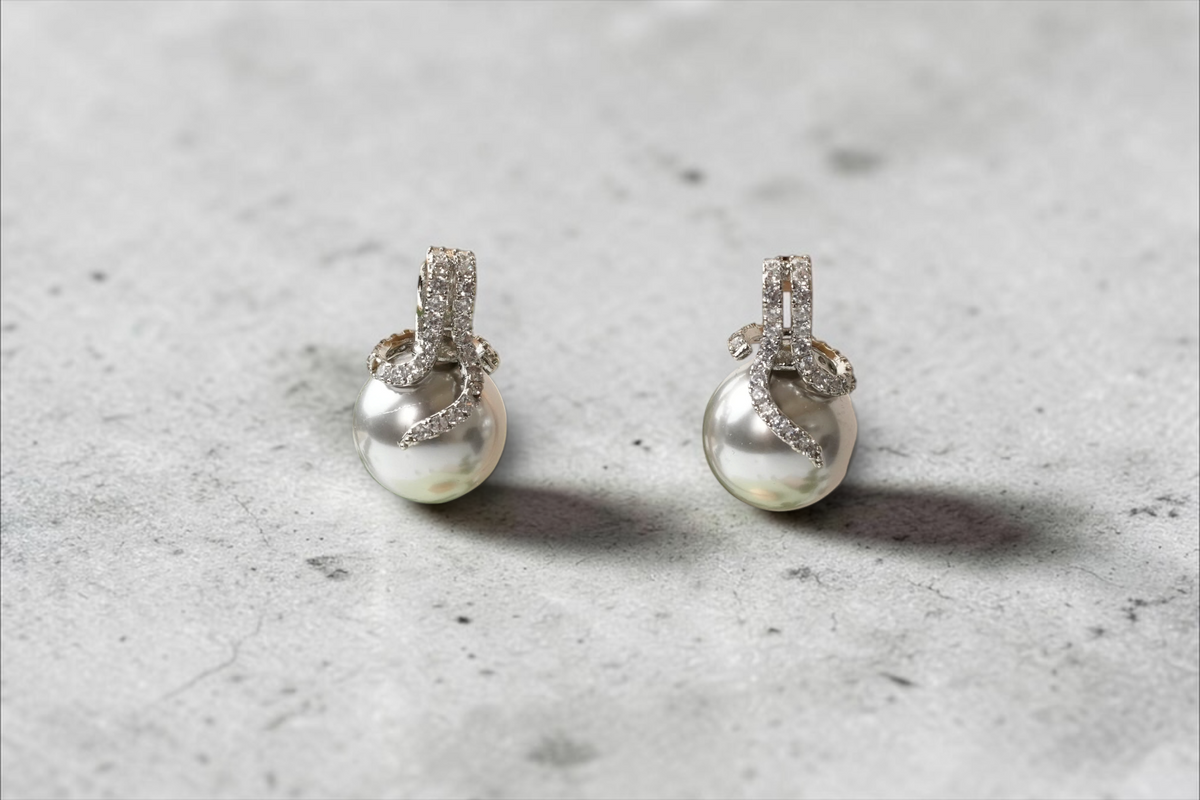 Daga-accessories silver-toned pearl drop earrings with cubic zirconia accents and swirling metallic mounts