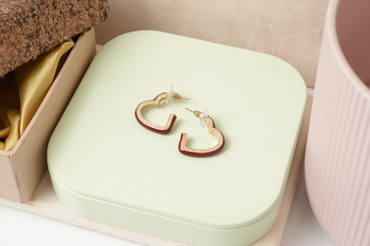 Daga-accessories heart-shaped hoop earrings with red enamel and pave-set stones on a gold-tone finish