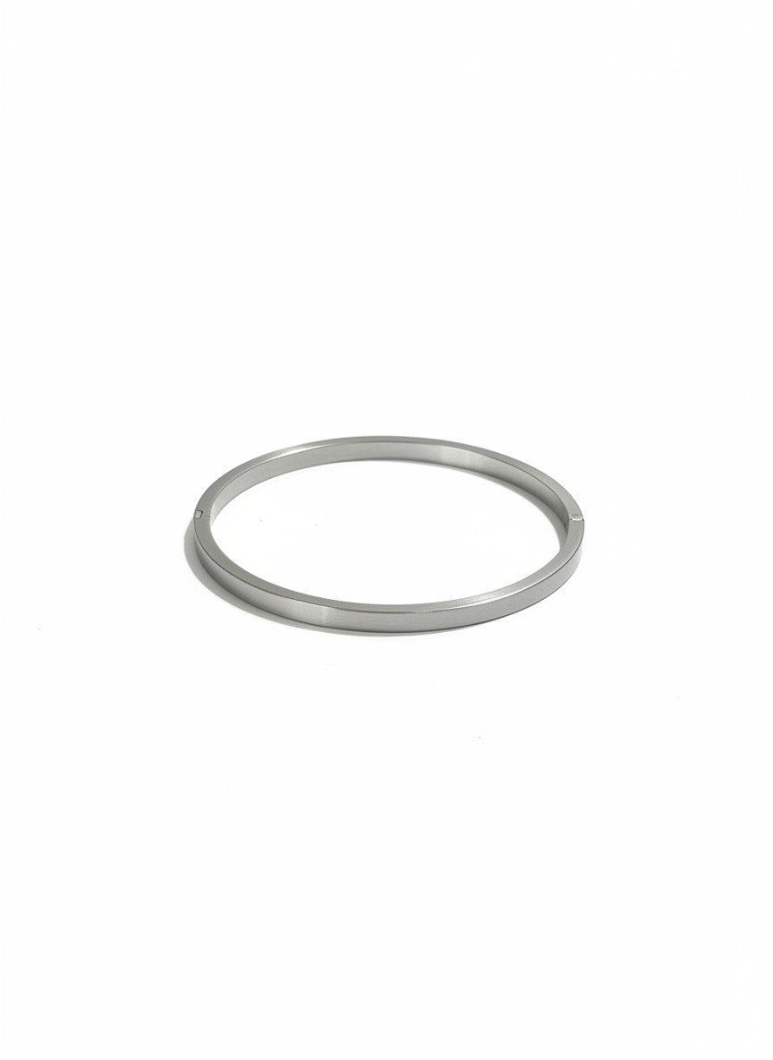 Daga-accessories minimalist silver-tone stainless steel bangle bracelet with a polished finish on a white background