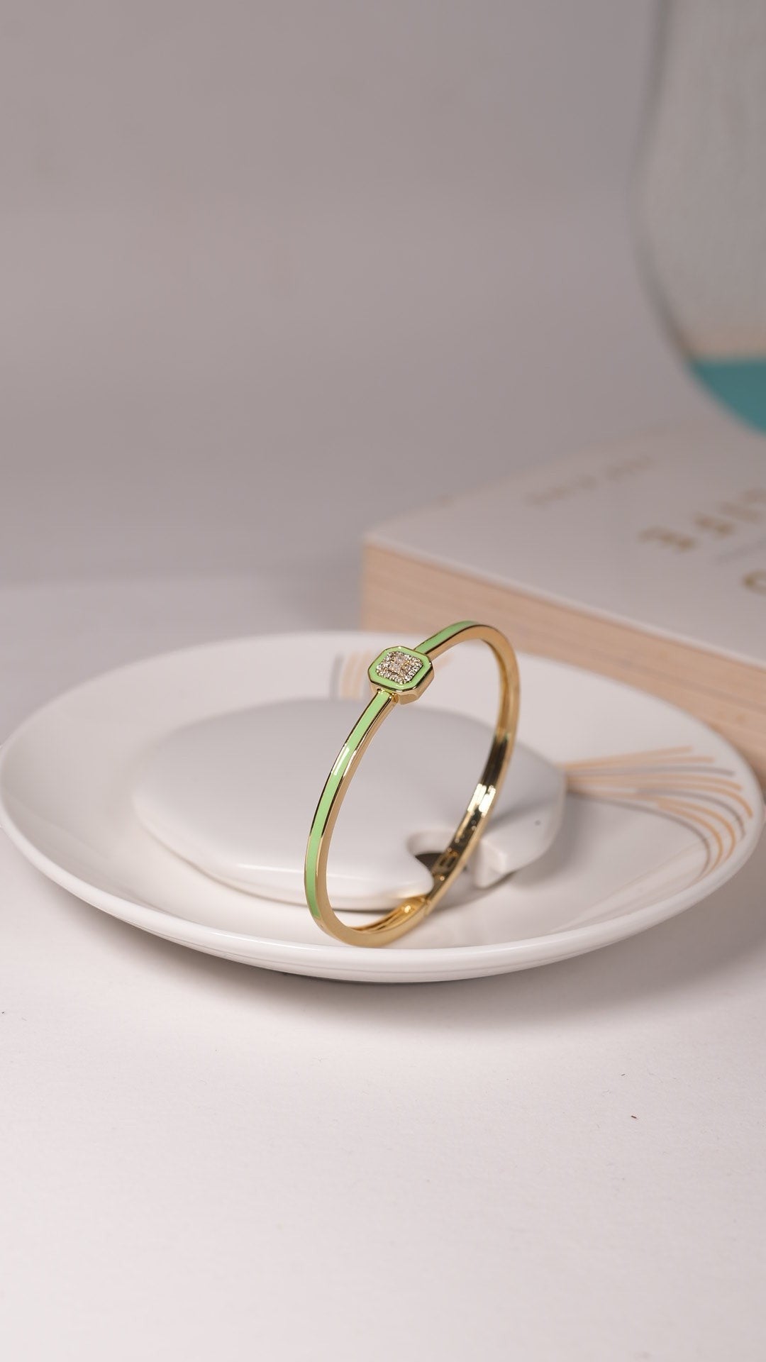 Daga-accessories mint enamel and gold tone bracelet featuring a square emblem with delicate crystal detailing.