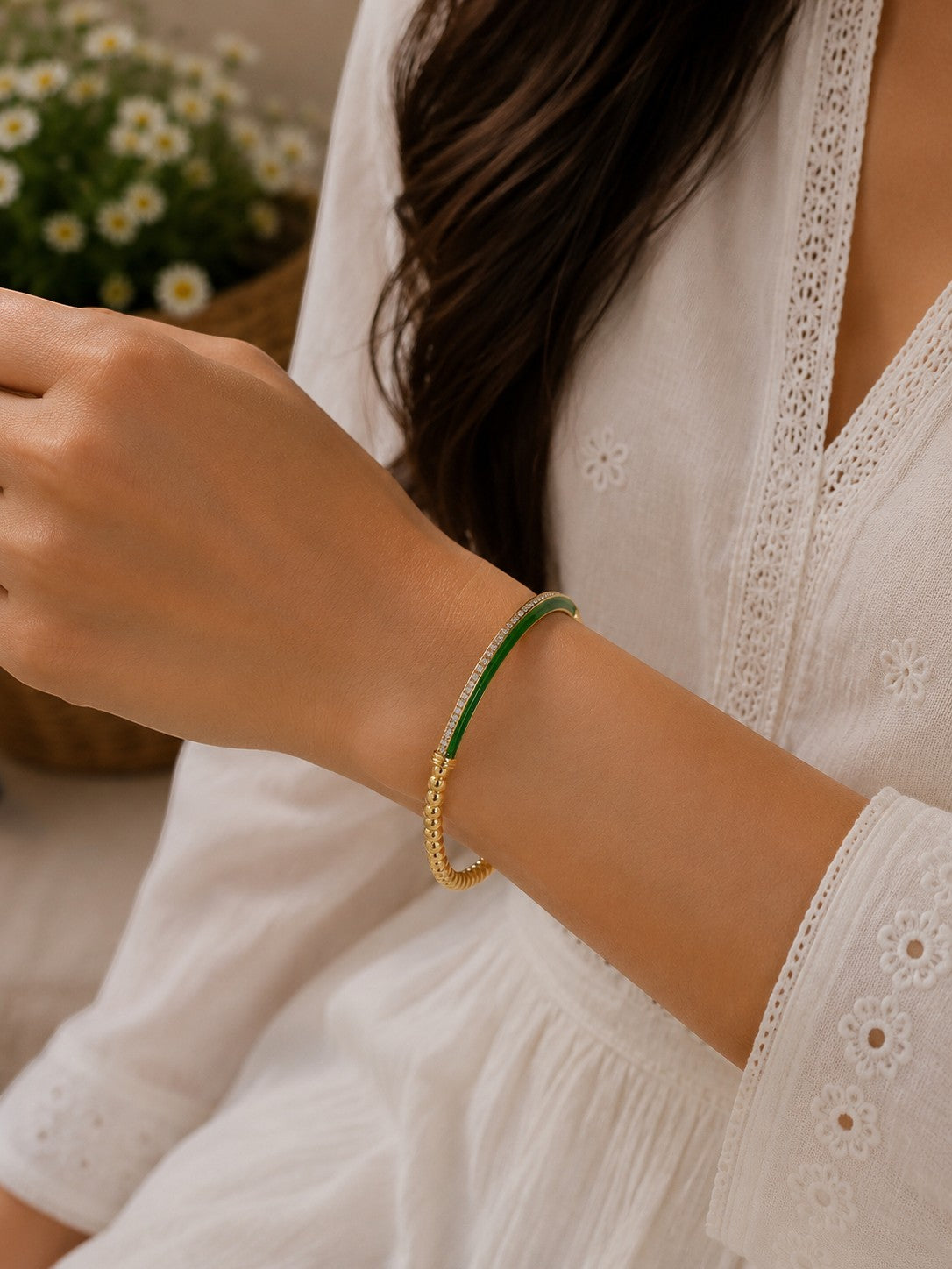 Daga-accessories Olive Slim Aura Bracelet with green enamel, gold beads, and crystal accents on a woman's wrist.