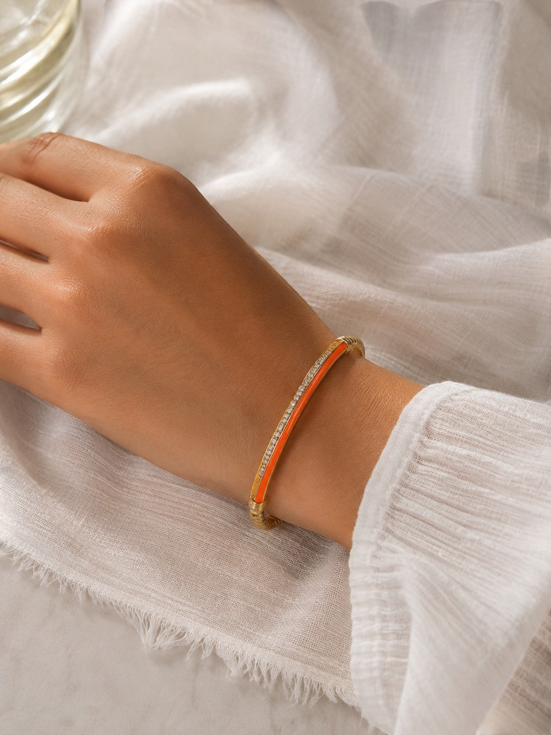 Daga-accessories orange slim aura bracelet with enamel finish and crystal accents worn on a wrist