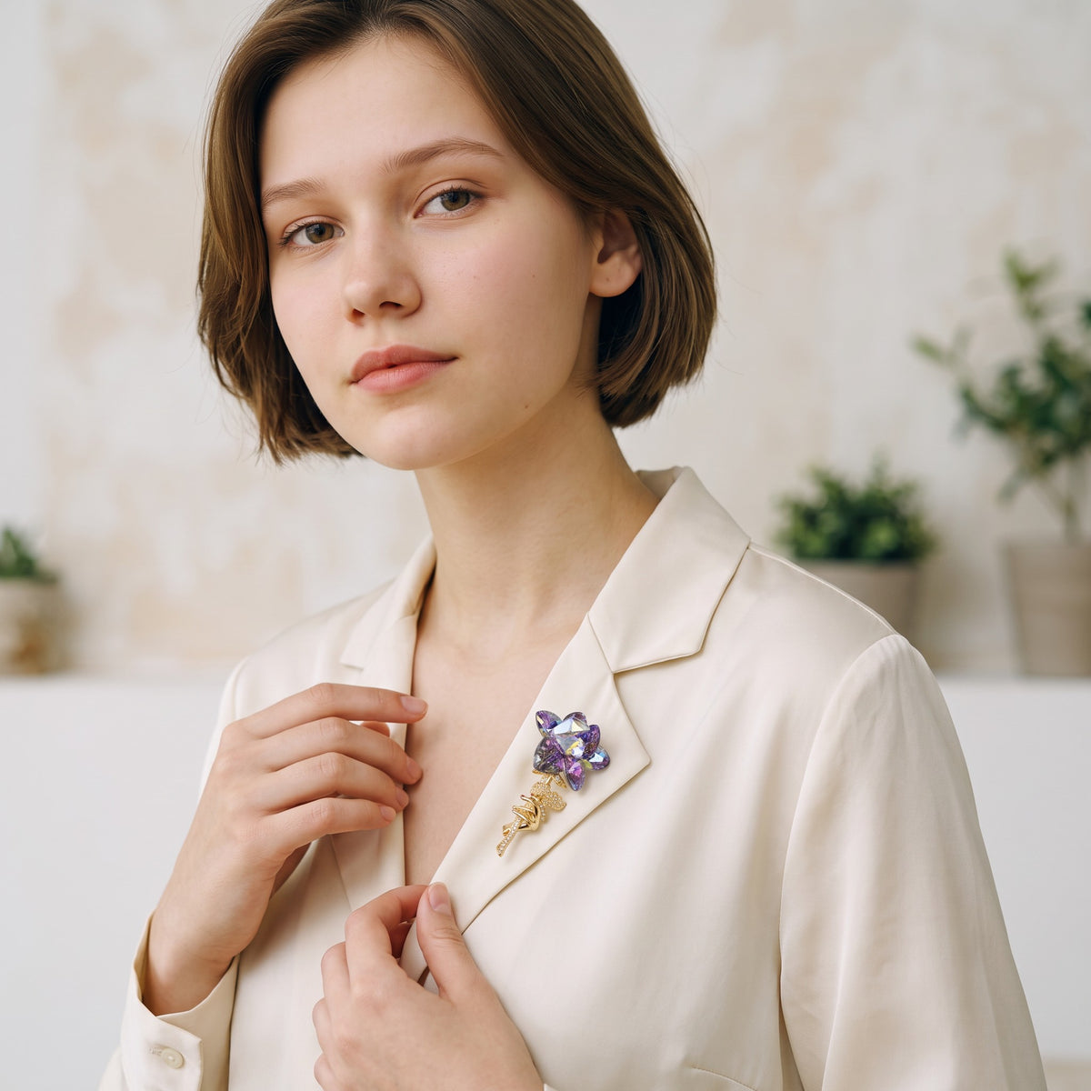 Daga-accessories purple crystal flower brooch pinned to a woman wearing a cream blazer