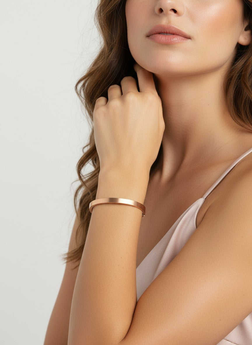 Daga-accessories minimalist rose gold-toned metal bangle bracelet worn on a woman's wrist