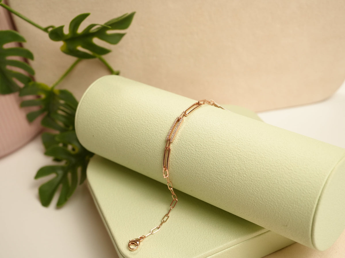 Daga-accessories rose gold link bracelet with delicate pavé detailing on a soft green display stand