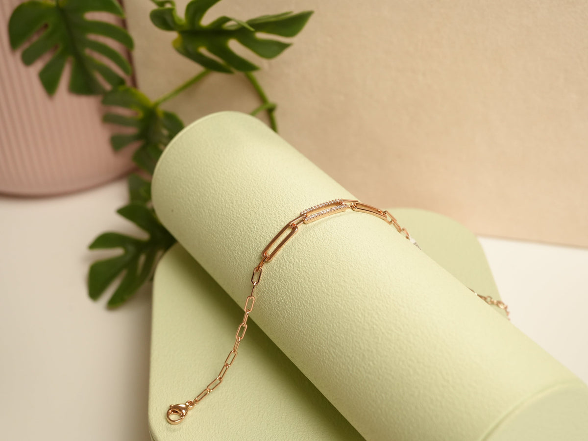 Daga-accessories rose gold link bracelet with delicate crystal accents on a minimalist green display stand