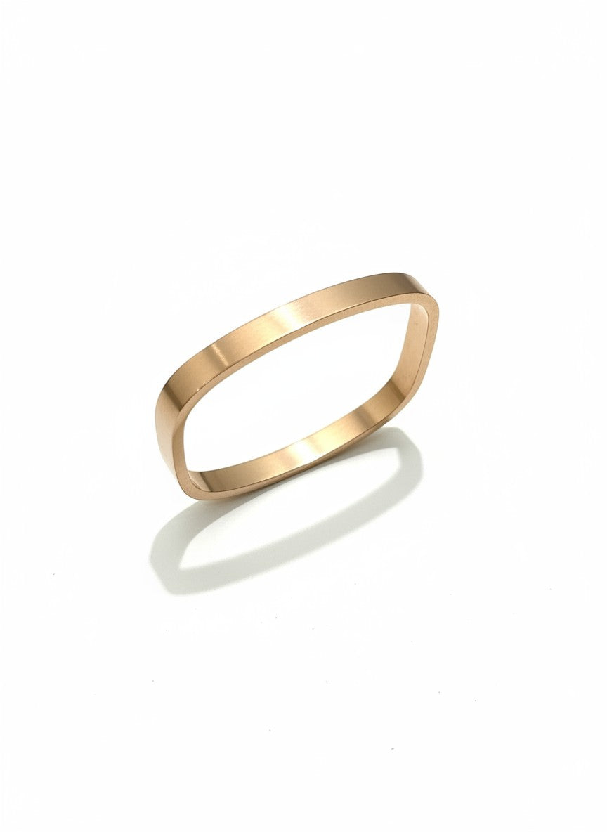 Daga-accessories minimalist rose gold-toned metal bangle with a sleek rectangular silhouette and polished finish.
