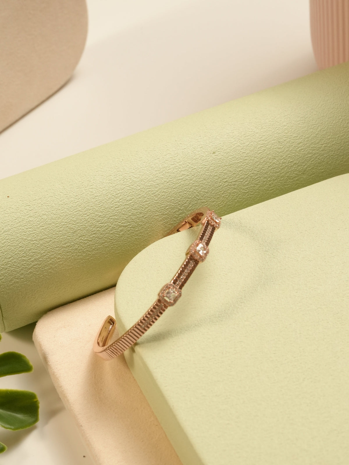 Daga-accessories rosegold square halo bracelet with bamboo-inspired sterling silver detailing on a green pedestal.