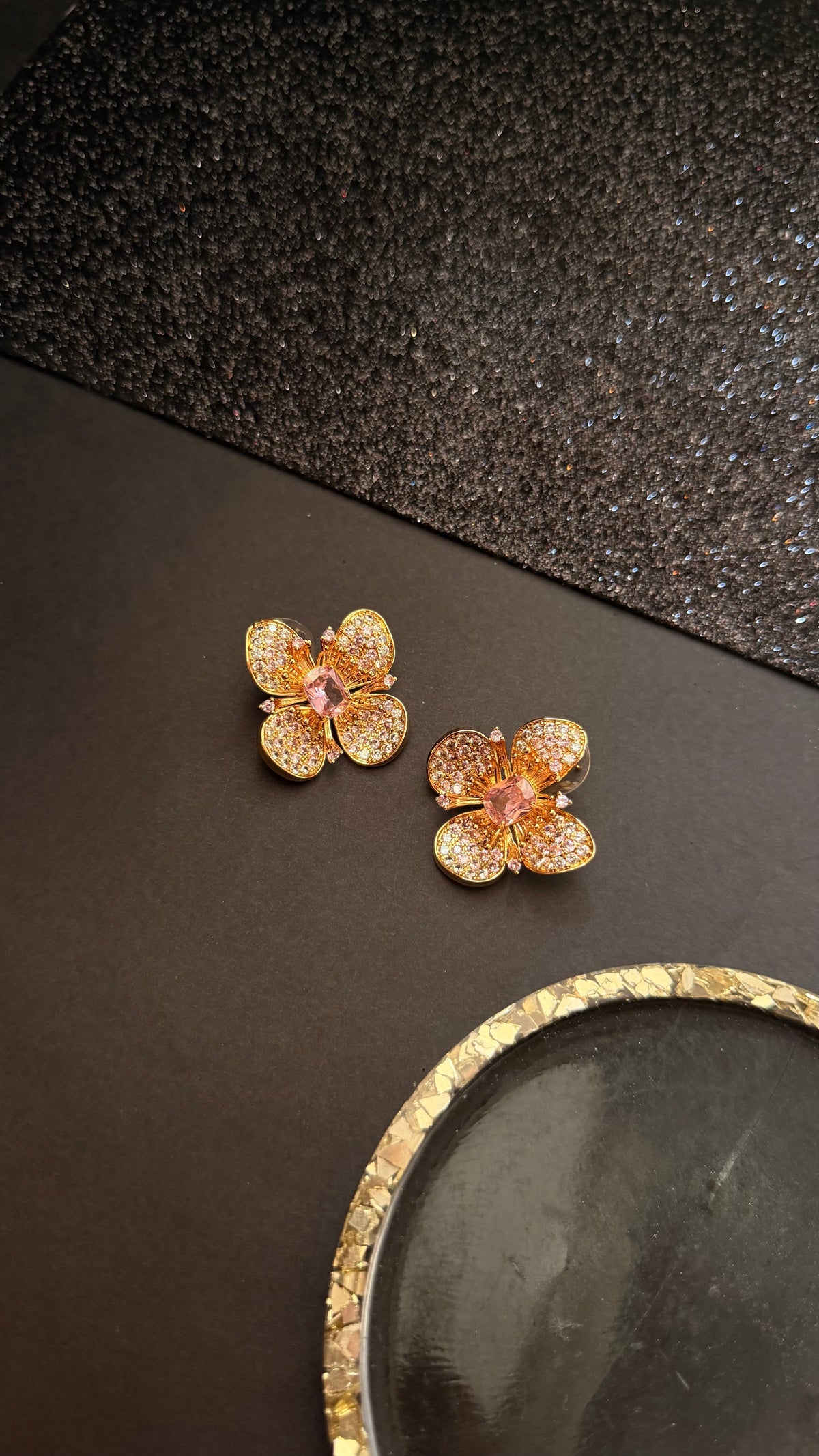 Daga-accessories Rosy bloom floral stud earrings with layered gold petals and shimmering pink center stones.
