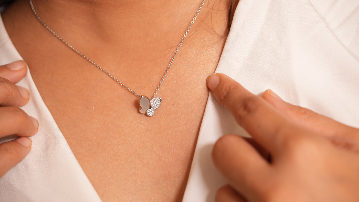 Daga-accessories silver butterfly pendant necklace with pavé stones and smooth inlay worn on a white blouse