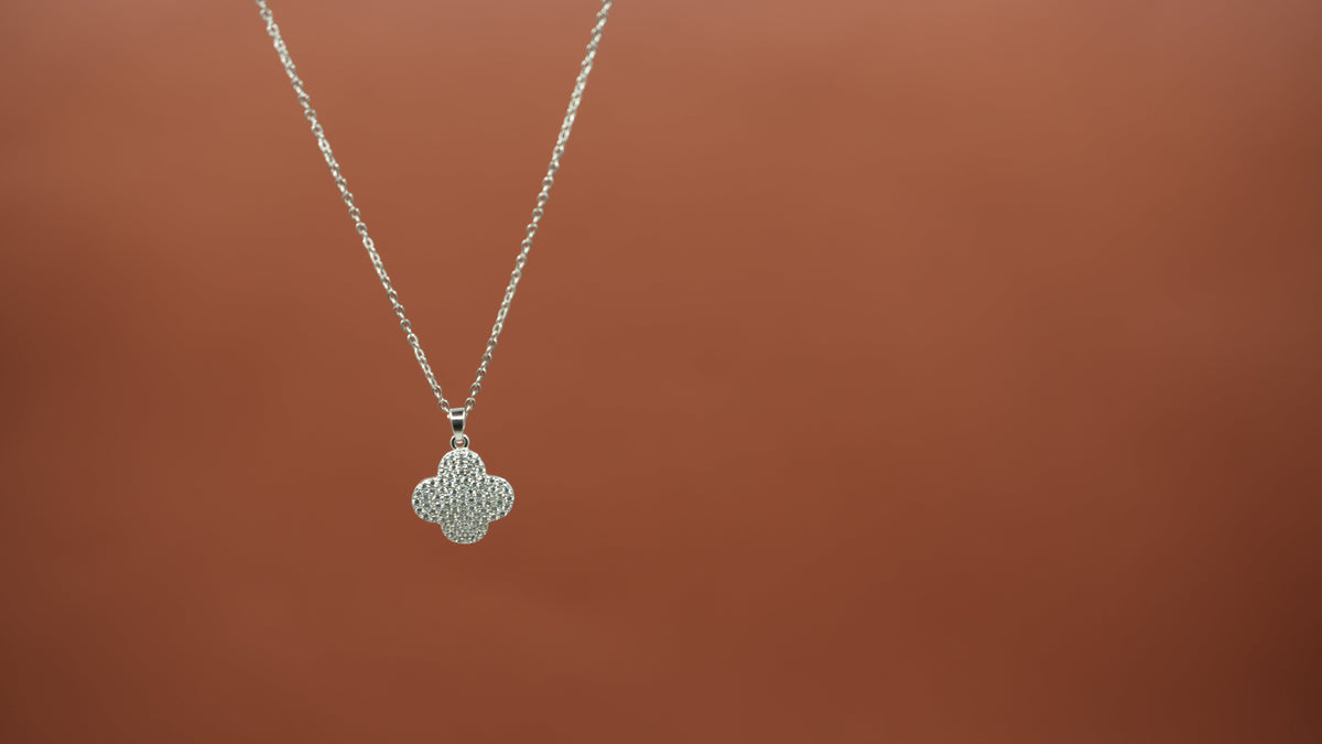 Daga-accessories silver clover necklace featuring a delicate chain and a sparkling stone-studded four-leaf pendant.