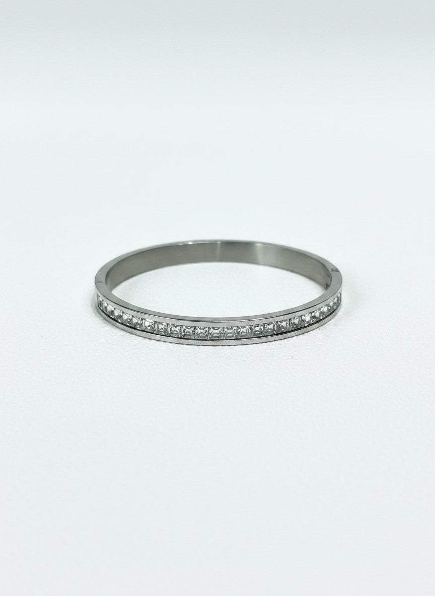 Daga-accessories silver-toned stainless steel hinged bangle bracelet featuring a row of square-cut clear crystals.