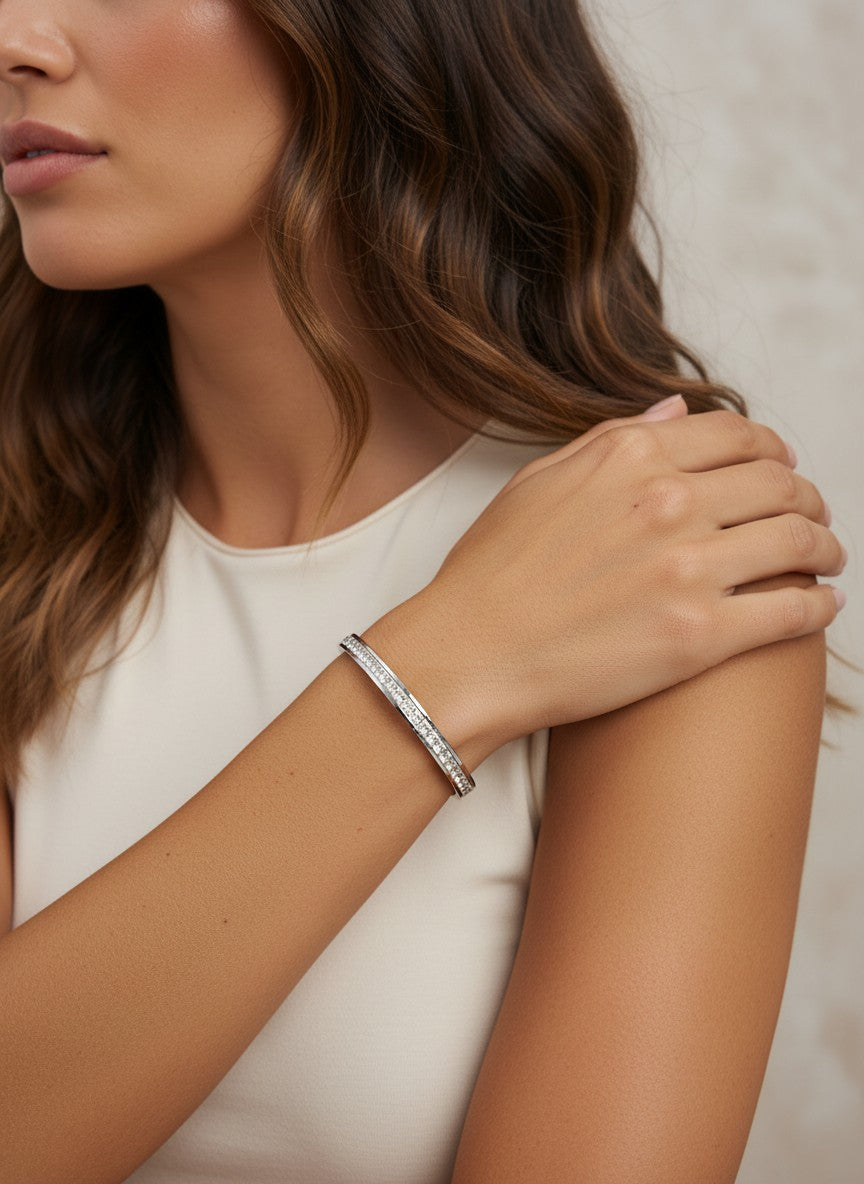 Daga-accessories silver-toned stainless steel hinged bangle bracelet with square-cut crystals worn on a woman's wrist