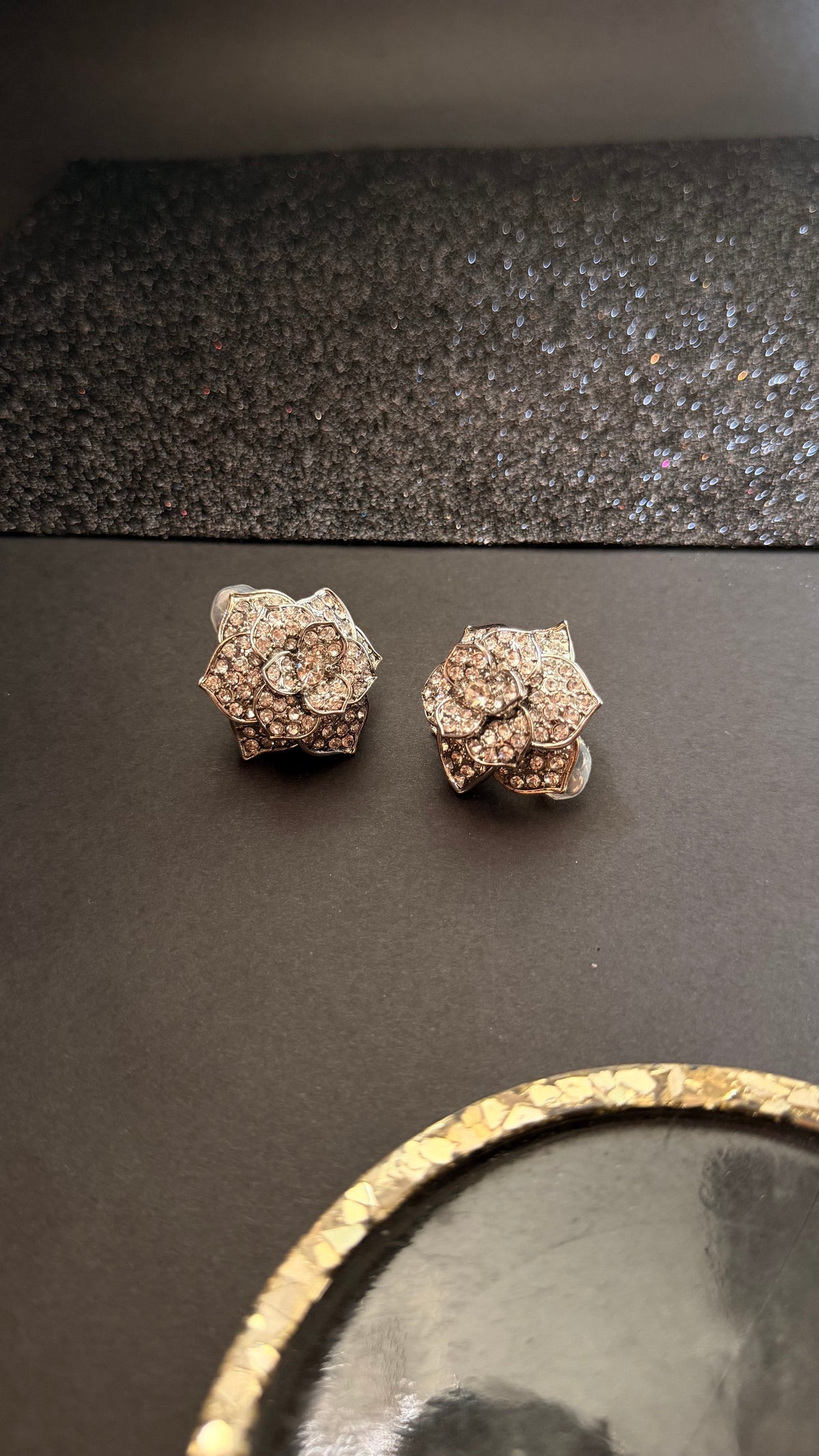 Daga-accessories silver floral stud earrings featuring layered rose petals encrusted with shimmering crystals.