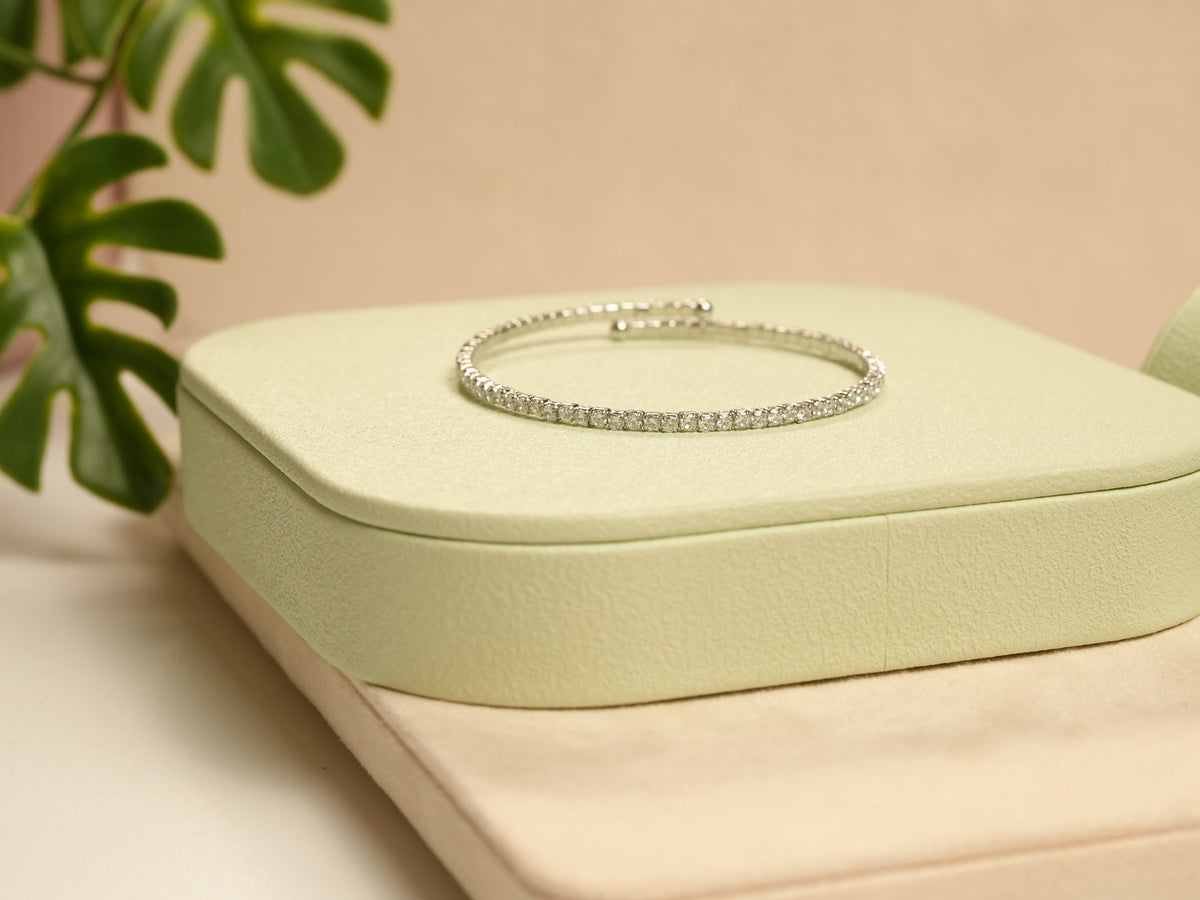Daga-accessories silver Radiant Grace bracelet with delicate studded detailing on a light green display stand.