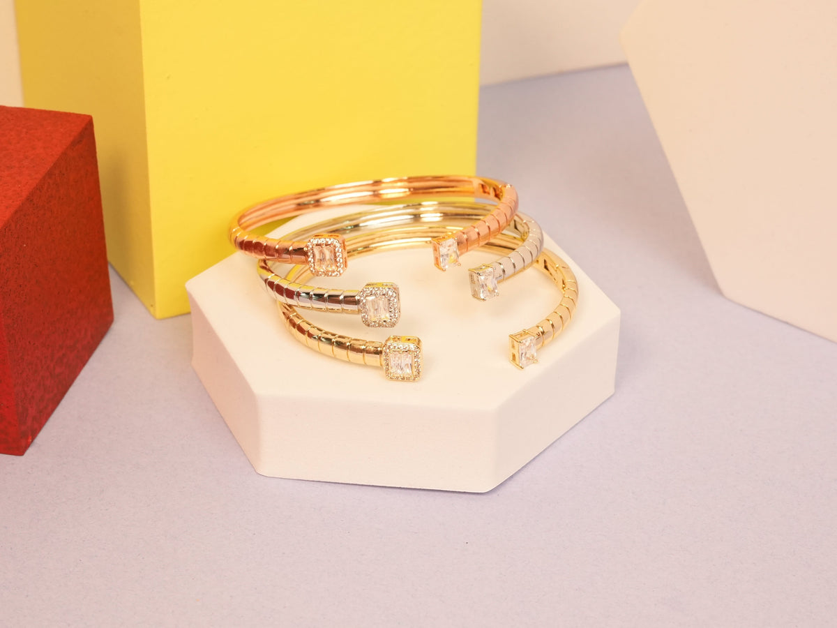 Daga-accessories stackable cuff bracelets in rose, yellow, and white gold with emerald-cut solitaire stones