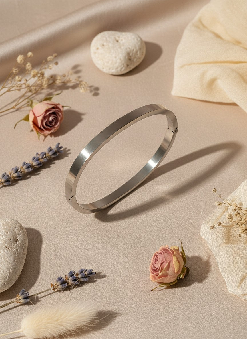 Daga-accessories minimalist stainless steel bangle with a polished finish, displayed on a neutral fabric background.