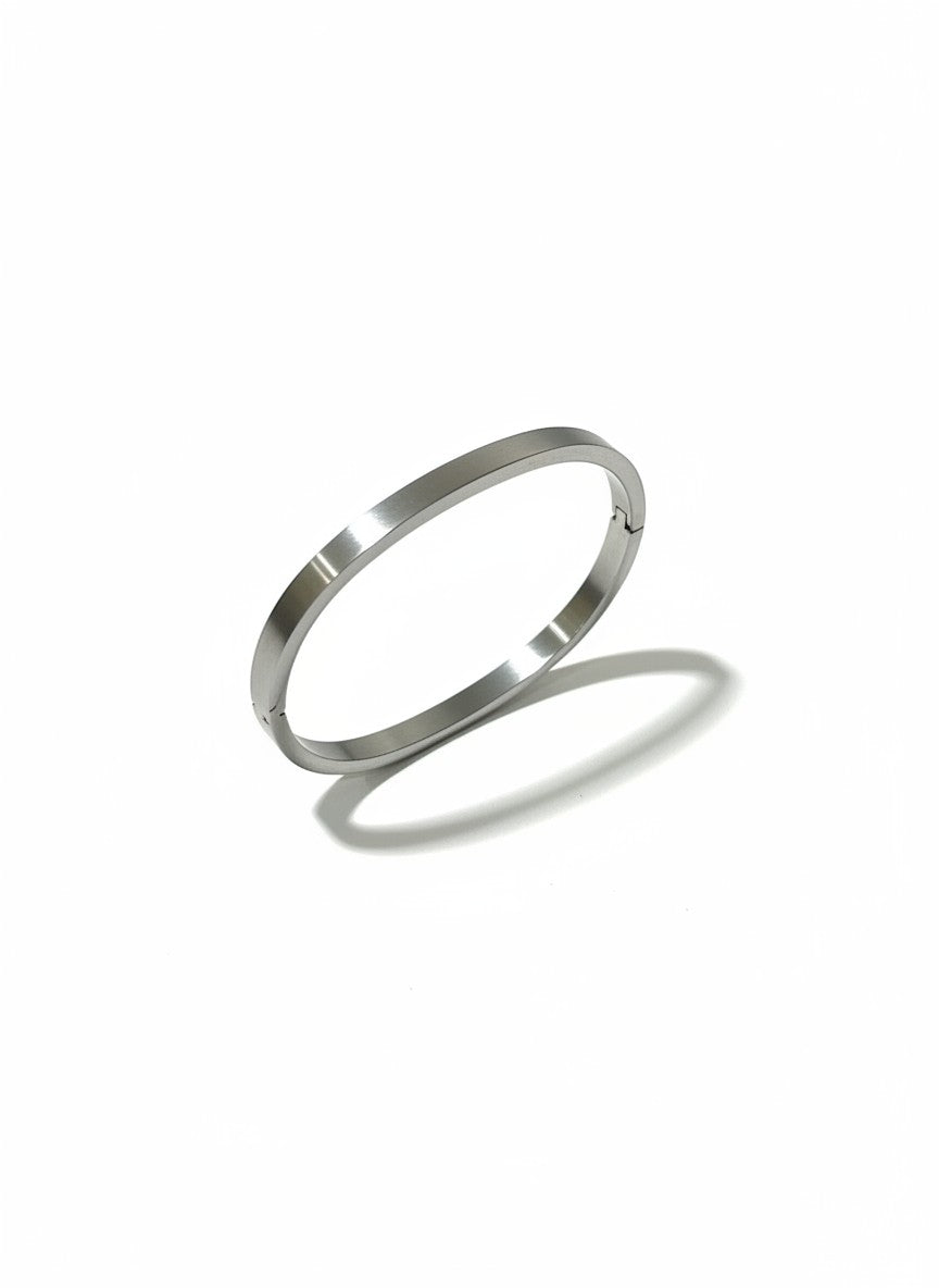 Daga-accessories minimalist stainless steel bangle bracelet with a polished silver finish and secure hinge closure.