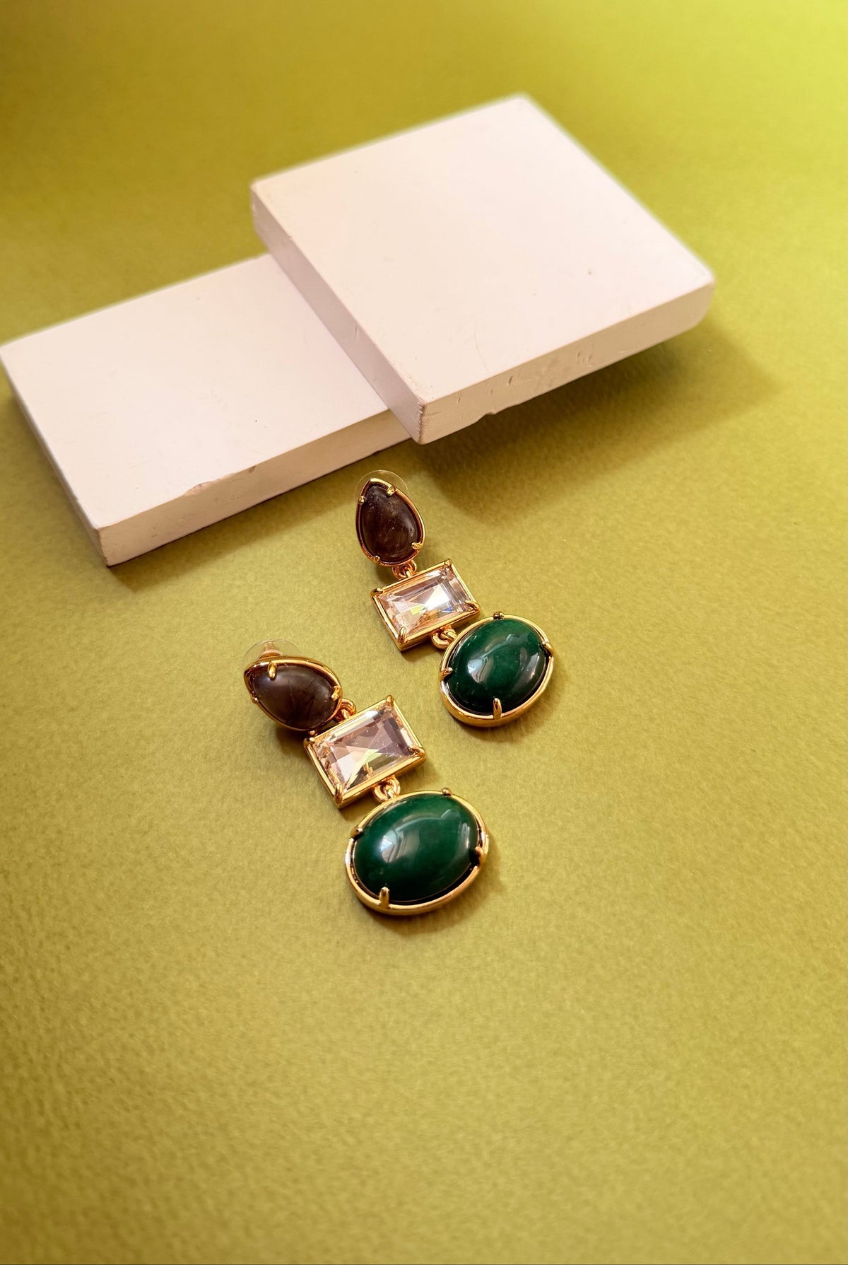 Daga-accessories long hanging earrings featuring a stacked trio of brown, white, and green stones in gold settings.