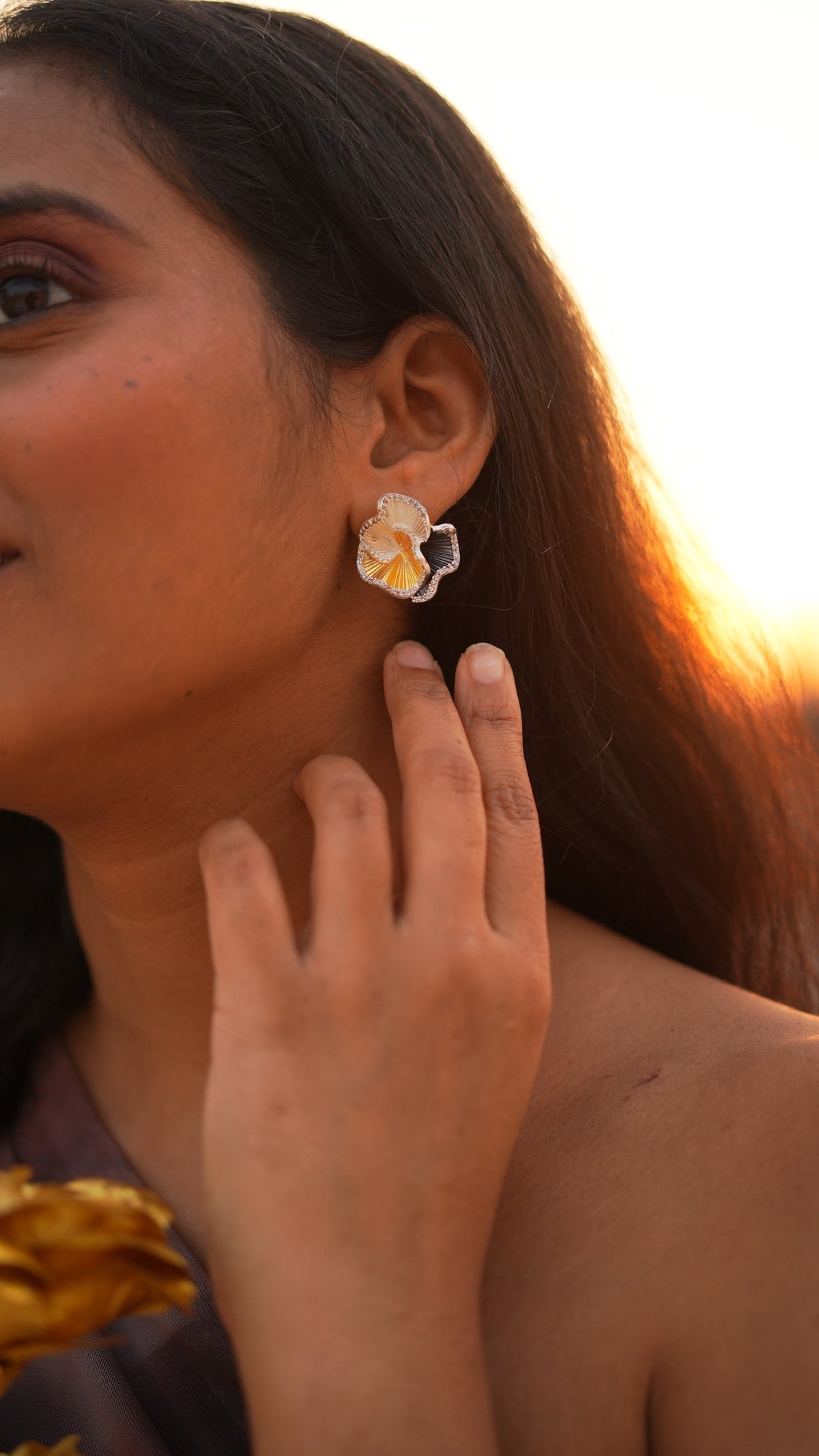 Daga-accessories Three Petal Elegance stud earring featuring gold and silver textured petals on a woman's ear