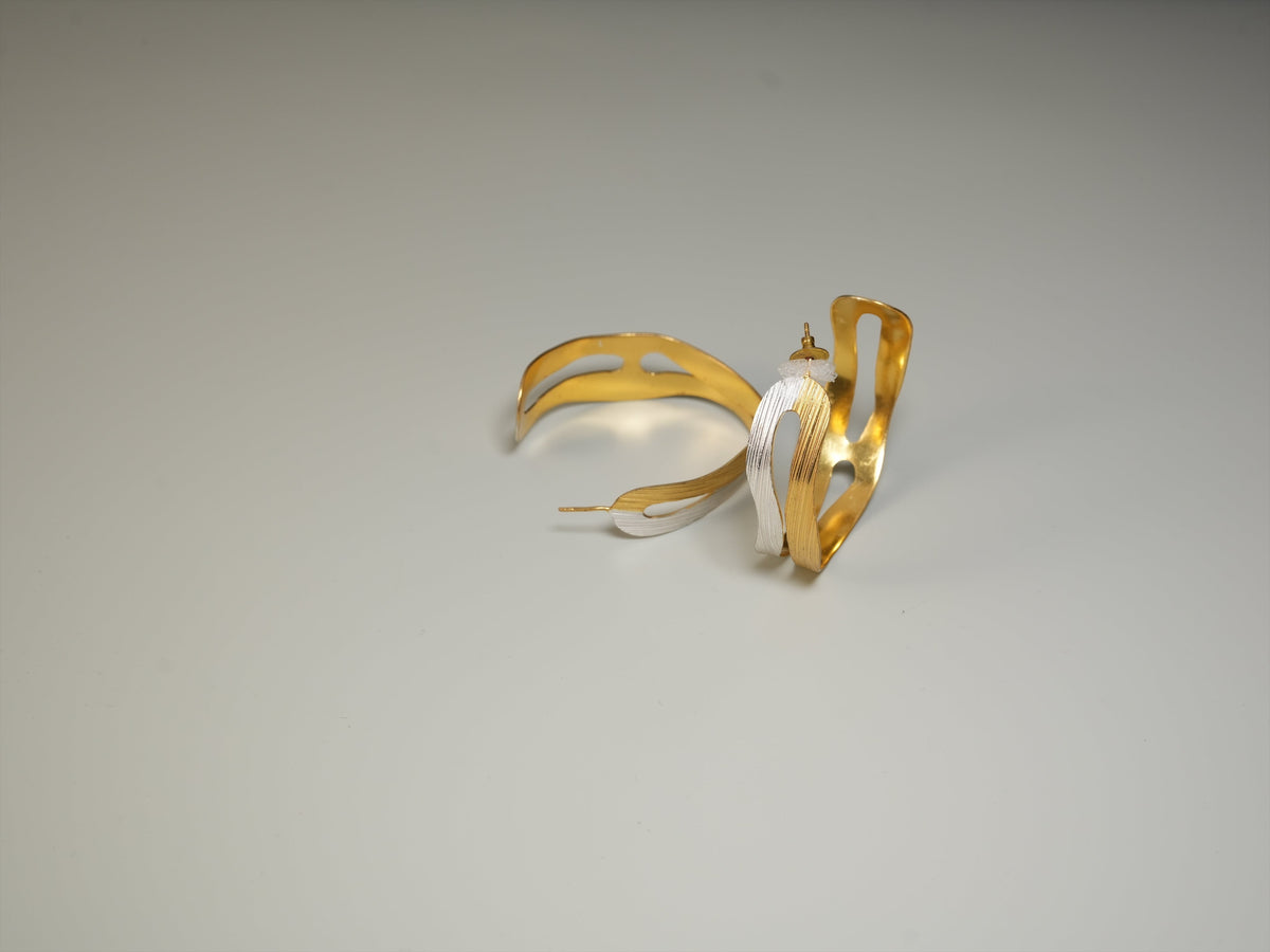 Daga-accessories two tone layered hoop earrings featuring a textured gold and silver finish on a neutral background